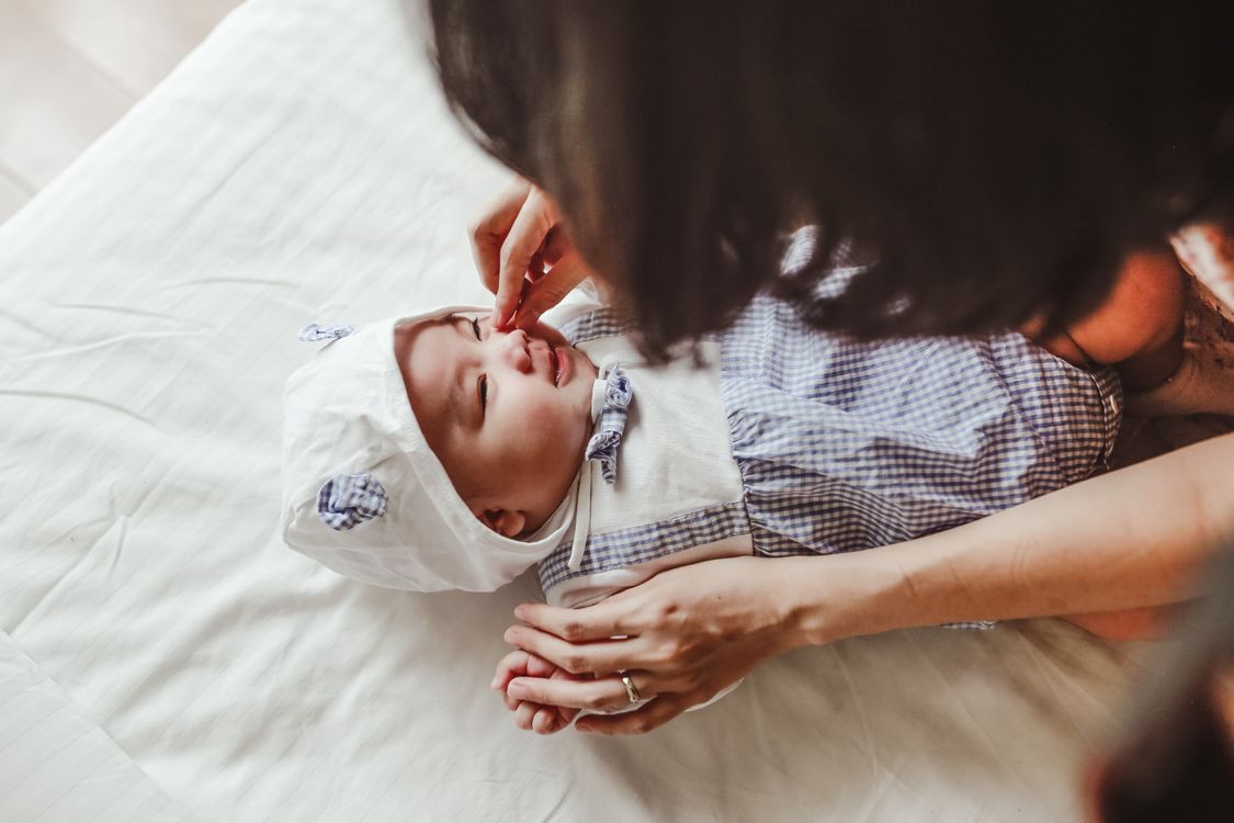 A mother gently touching her newborn baby's cheek
